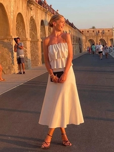 Detail shot of a French chic beige tube top and pleated midi skirt set in an elegant style