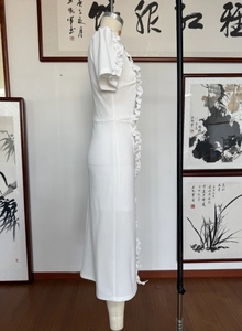 Close-up of elegant white dress featuring ruffled edge detailing and textured fabric