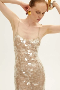 Close-up of slim strap sequin dress with sparkling white sequins on beige mesh fabric