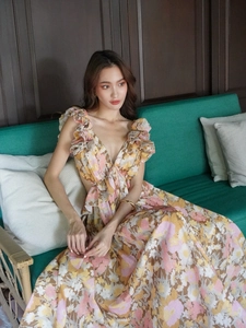 Detail of floral V-neck dress with bow tie, ruffled shoulders and waist cut-outs