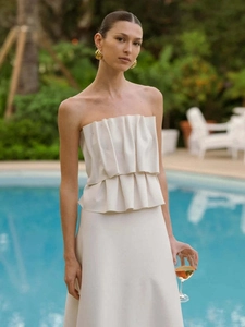 Detail of elegant off-shoulder beige evening dress with tiered ruffles and pleated design