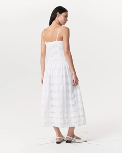 Détail de la texture quadrillée blanche et des fines bretelles de cette élégante robe midi