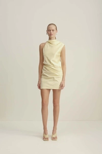 Détail de l'épaule asymétrique et du tissu en satin froncé sur la robe jaune élégante