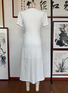 Detail view showing the back of an elegant white puff sleeve party dress with ruffles