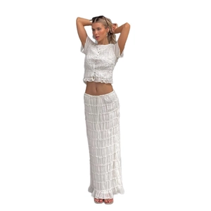 Women's two-piece white pleated set with buttoned short top and ruffled maxi skirt