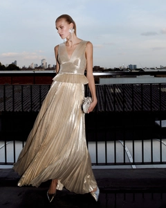 Detail of metallic pleated evening gown with deep V-neck and ruffled waist peplum