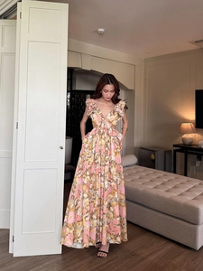 Detail of floral maxi dress with deep V-neck, ruffles, and side waist cut-out accents