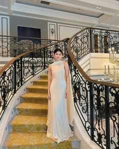 Elegant satin evening gown with sleeveless halter neck and floor-length cape detail