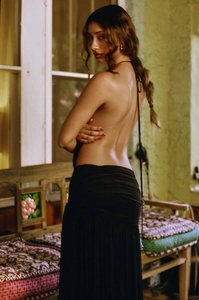 Close-up of elegant black backless halter dress featuring deep V-neck and draped fabric