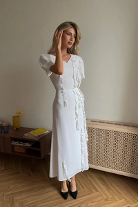 Detail of white midi evening dress featuring puff sleeves and elegant ruffle accents