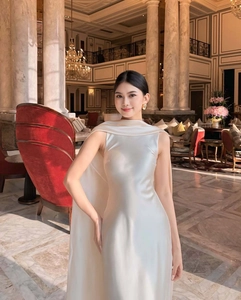 Detailed view of elegant pearl white satin evening dress with stand collar and cape design
