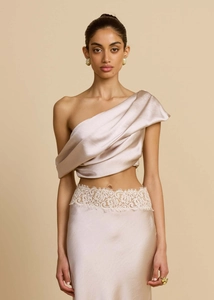Detail of champagne satin two-piece set featuring asymmetrical neck and lace waist trim