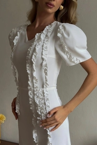 Detailed view of the ruffle trim and puff sleeves on this elegant white V-neck dress