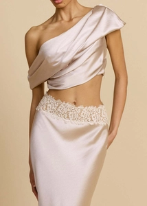 Detail of satin evening gown featuring asymmetrical one-shoulder top and lace waist trim