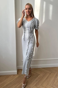 Detailed view of silver puffed sleeves and ruffle trim on elegant party evening dress