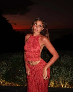 Detailed texture of the halter top and tiered ruched long skirt in brick red