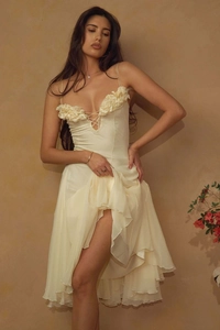Detail of cream evening dress showing 3D floral accents and tiered ruffle hemline