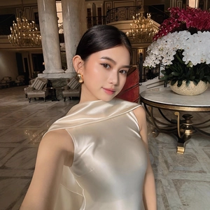 Elegant sleeveless champagne satin evening gown in a luxury hotel lobby setting