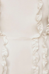 Close-up of double-layered ruffles and crepe texture on cream elegant evening dress