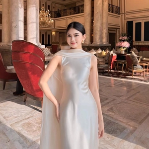 Elegant white satin sleeveless evening gown with cape detailing and a slim silhouette