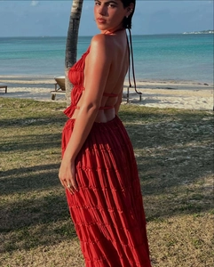 Detail of red backless halter maxi dress with layered ruffle hem on a sunny beach