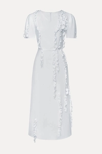 Detailed view of layered ruffles and light woven fabric on an elegant white evening dress