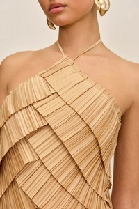 Detailed close-up of tiered pleats on a light brown halter neck evening gown for women