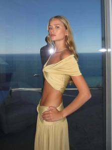 Champagne satin two-piece set featuring a twisted crop top and high-waisted pleated maxi skirt