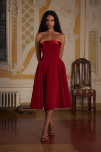 Détail de robe de cocktail bustier rouge coupe évasée avec bordure en satin et plis élégants