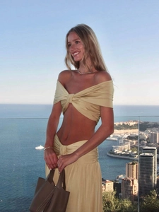 Detail of beach vacation two-piece set featuring twisted off-shoulder top and maxi skirt