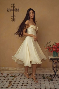 Detail of elegant off-white chiffon dress with 3D floral applique and delicate straps