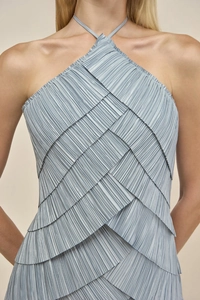 Detail showing tiered pleated texture and light blue silk-like fabric of a halter evening dress