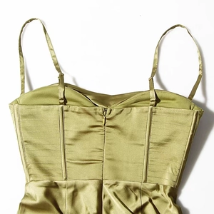 Detail view of olive green satin dress featuring pleated texture and hidden zipper
