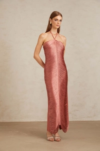 Détail d'une robe longue rose poudré avec franges, licou et coupe ajustée élégante