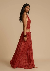 Side view of terracotta halter crop top and tiered bohemian skirt with pleated texture