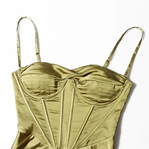 Detail view of grass green satin corset top with spaghetti straps and structured stitching