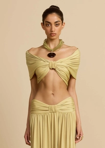 Detail of the knot-front off-shoulder top and high-waisted skirt in light olive green