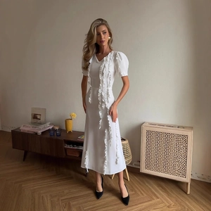 Elegant white mid-length dress with ruffle details, puff sleeves, and a subtle V-neckline