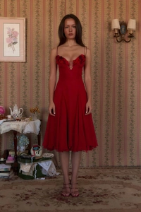 Detailed view of red evening dress featuring 3D floral appliques and deep V-neckline