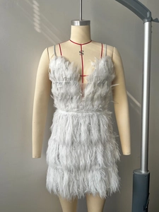 Close-up of deep V-neck detail and dense white feather fringe on the mini dress
