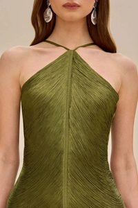 Gros plan détaillé sur le tissu plissé de la robe dos nu vert olive et boucles d'oreilles