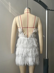 Detail of white feather mini dress showing backless V-cut design and thin silver straps