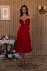 Close-up of red evening dress with 3D floral applique and deep V-neckline detail