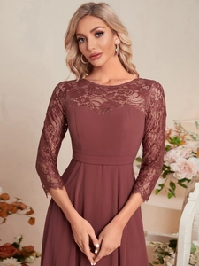 Close-up of the delicate lace neckline and sheer sleeves on a dusty rose evening gown