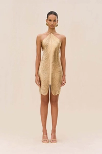 Détails des franges dorées scintillantes sur une robe de soirée courte à col licou chic