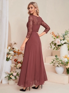 Close-up of elegant burgundy lace embroidery and sheer sleeves on formal evening dress