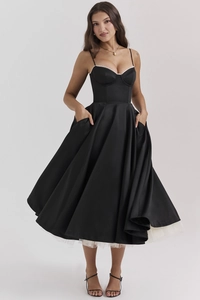 Dettaglio dell'abito da sera in raso nero con corpetto a corsetto e strato di sottogonna in tulle