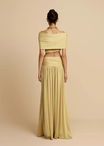 Detail view of mustard yellow satin maxi skirt and off-shoulder top back silhouette