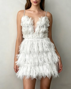 Close-up of white feather mini dress featuring a deep V-neck and mesh details
