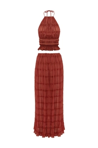 Detail of rust red tiered maxi skirt and halter top set with pleated texture fabric